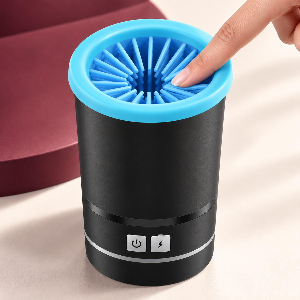 Hand pressing the soft blue silicone bristles inside the black Lorzini paw cleaner